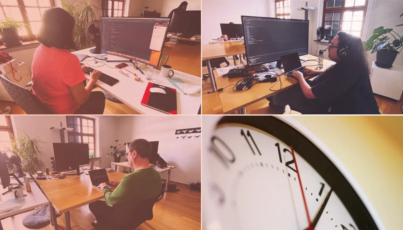 Trois développeurs à leur poste de travail et une horloge